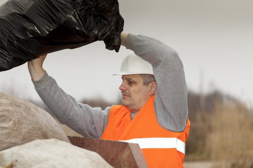 Workers loading commercial rubbish into a truck with PPE